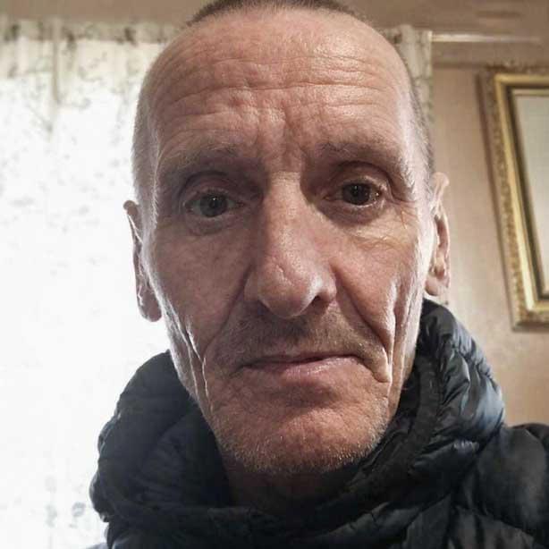 Another close-up selfie of Francis Croft. He is wearing a dark jacket and looking directly at the camera, with household furnishings visible in the background.