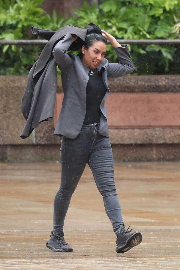 Christina Emanuel walking outside a court building, wearing a coat and carrying a bag, photographed during her assault case. Credit: Liverpool Echo.